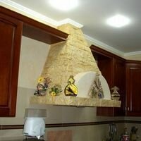 вытяжка пирамидальной формы на кухне отделана искусственным камнем скалистый песочного цвета