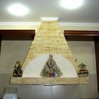 дикий камень скалистый точно повторяет геометрию встроенной вытяжки на кухне частного дома