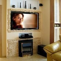 искусственный камень скалистый в интерьере гостиной выделяет камин и украшает телевизор