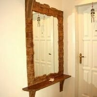 зеркало и арка в прихожей квартиры оформлены диким камнем скалистый