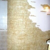 Радиусная стена на кухне частного дома отделана интерьерным камнем скалистый мраморного цвета