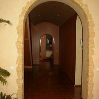 полукруглая арка в гостиной частного дома отделана камнем скалистый