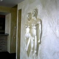 интерьер гостиной украшен креативным панно в виде каменных скульптур мужчины и женщины