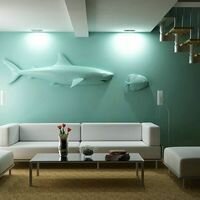 интерьер гостиной в частном доме украшает креативное панно из камня в виде силуэта акулы и рыбы