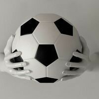 креативный декор в виде рук, держащих футбольный мяч, изготовлен из дикого камня