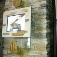 креативный декор из камня в виде рук, держащих монитор, привлекает внимание покупателей в магазине