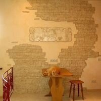 интерьерный камень скалистый и фреска с египетскими мотивами выгодно подчеркивают интерьер кухни