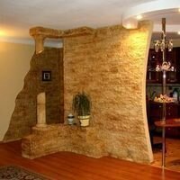 многоуровневая фигура из гипсокартона, украшенная декоративным камнем , играет главную роль интерьере гостиной