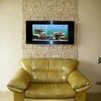 декоративный скалистый камень песочного цвета выгодно подчеркивает аквариум в интерьере квартиры