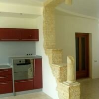 интерьерный камень скалистый и римские колонны из камня украшают стену кухни в частном доме