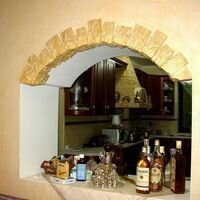 искусственным камнем скалистый украшено арочное окно кухни частного дома