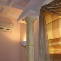 римская колонна из камня вместе с портиком вносят римский стиль в интерьер кабинета