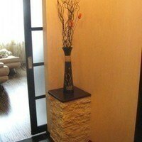 Гипсовый декоративный камень украшает колонну в квартире