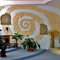 креативное панно в холле частной школы в виде спирали знаний оформлено декоративным камнем скалистый